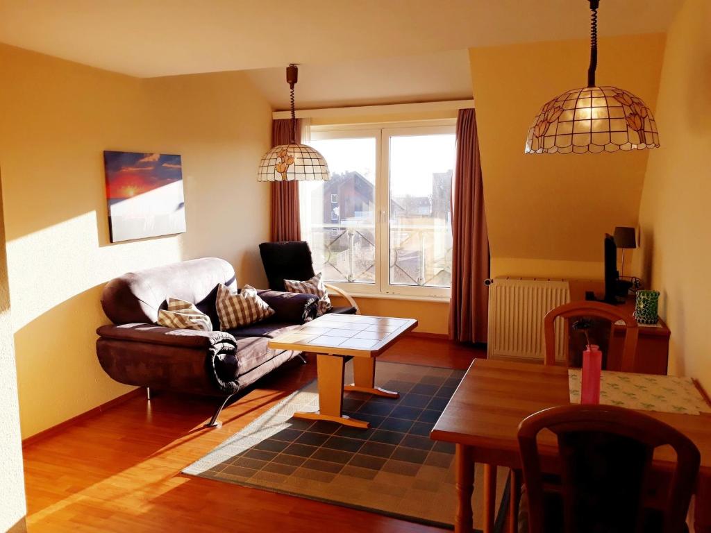 Haus Strandgang, Whg 11 في كيلينهوسن: غرفة معيشة مع أريكة وطاولة