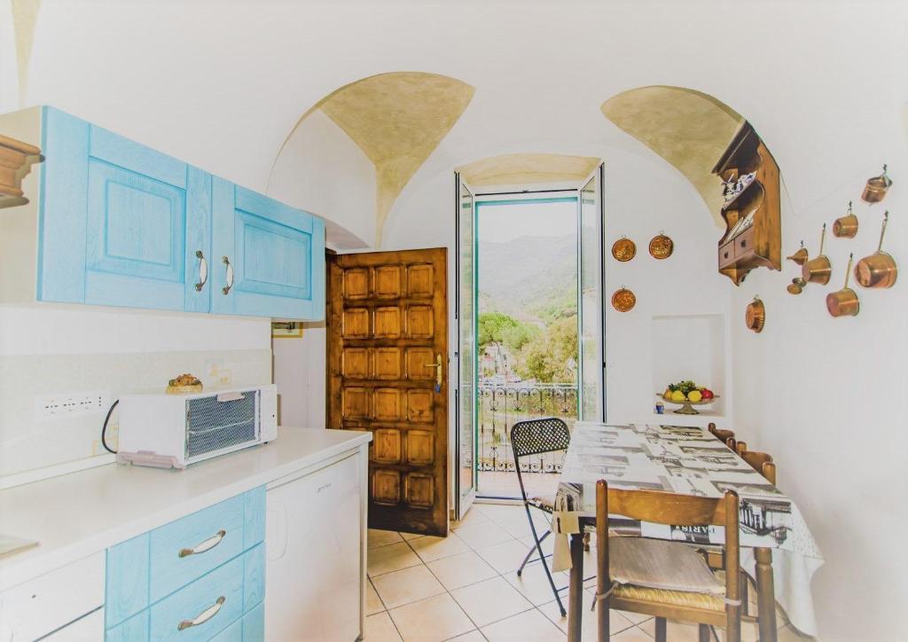 una cucina con armadi blu e un tavolo con forno a microonde di BELLAVISTA a Dolceacqua