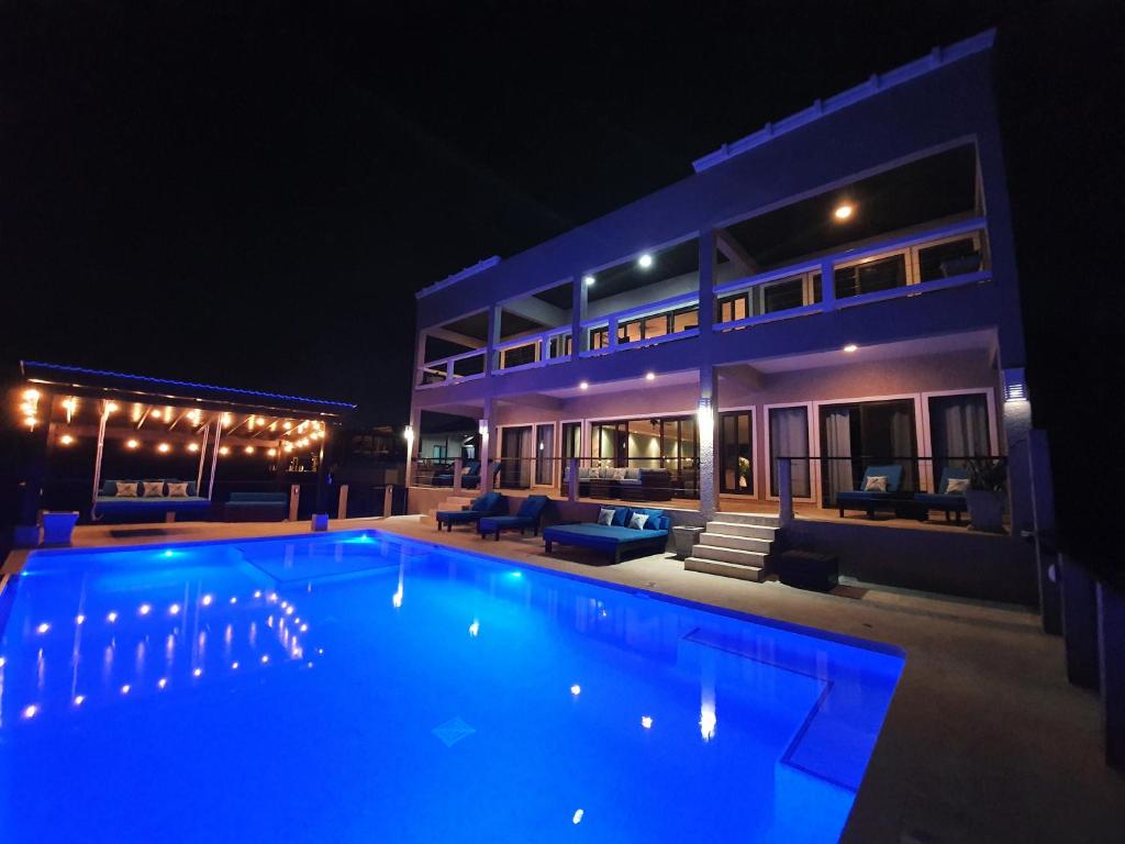 a swimming pool in front of a house at night at Fishers Landing Boutique Hotel in Roatán