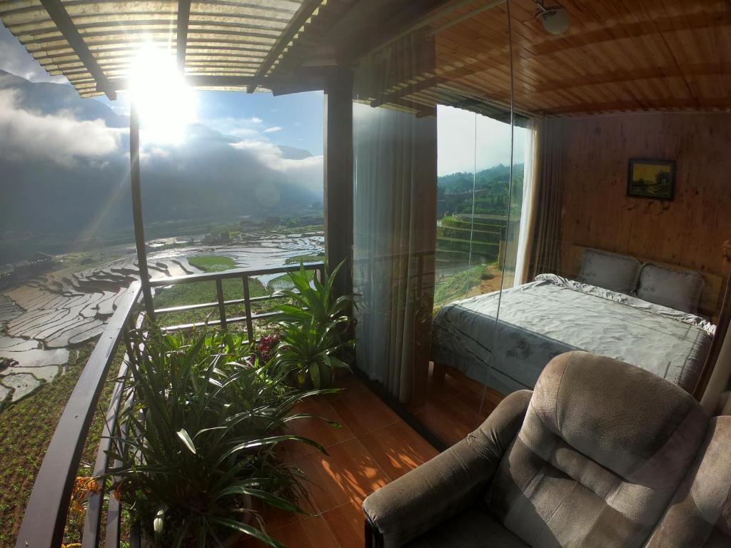 a room with a bed and a balcony with a view at Amica House in Sa Pa