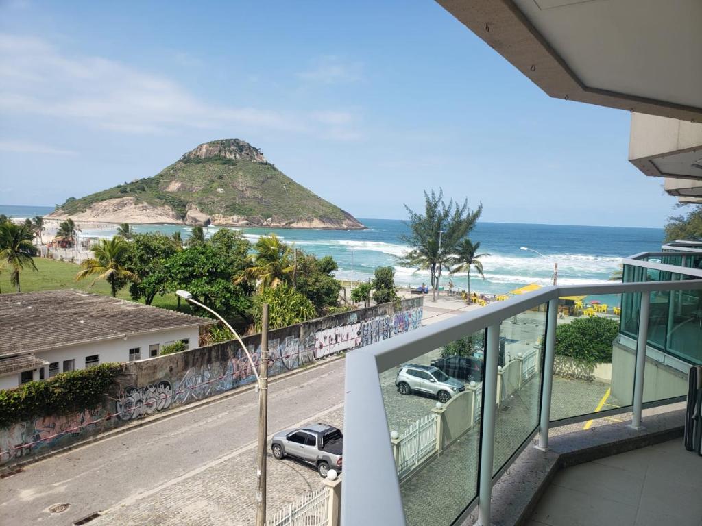 einen Balkon mit Blick auf den Strand und das Meer in der Unterkunft Villas del Sol praia da macumba in Rio de Janeiro