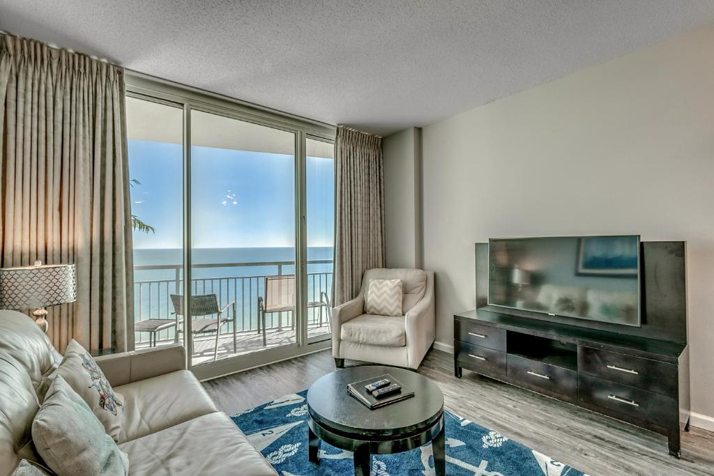 a living room with a couch and a television and a chair at Newly Renovated Ocean Front Condo, Modern Decor, Central MB, 20th floor in Myrtle Beach