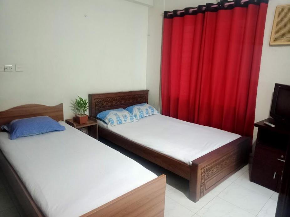 - 2 lits dans une chambre avec rideau rouge dans l'établissement Marry House, à Dhaka