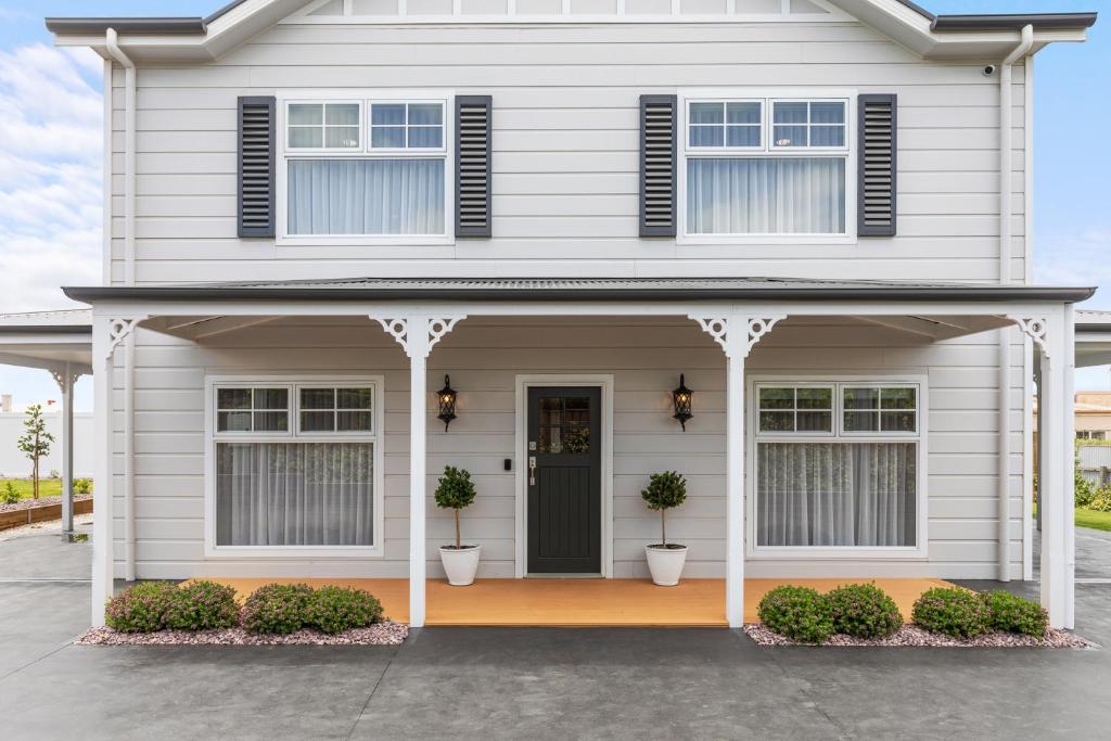 a white house with a black door at Foxmount Estate Magnus 2 bedroom in Mount Gambier