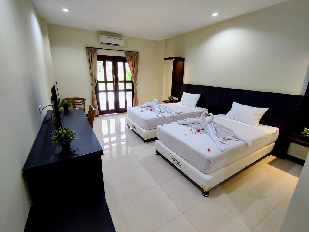 um quarto de hotel com duas camas e uma secretária em Crystal City Hotel em Mataram