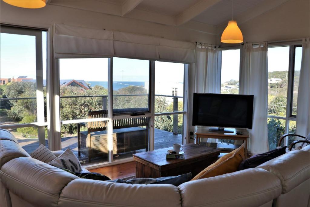 a living room with a couch and a large window at Marians in Aireys Inlet