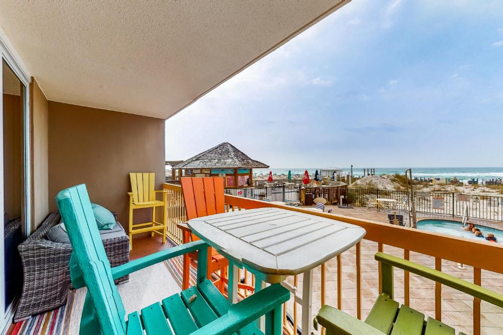 einen Balkon mit Tisch und Stühlen sowie Strand in der Unterkunft Pelican Beach Resort III in Destin