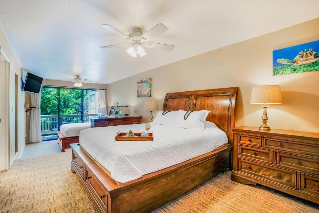 a bedroom with a bed and a ceiling fan at Hale Moi #103B in Princeville