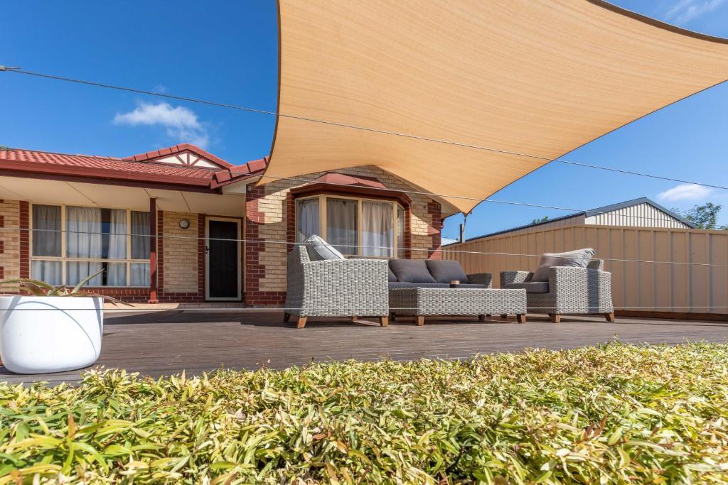 a patio with two couches under a large umbrella at 4 Pelican Court, Woodlane Mypolonga. in Mannum