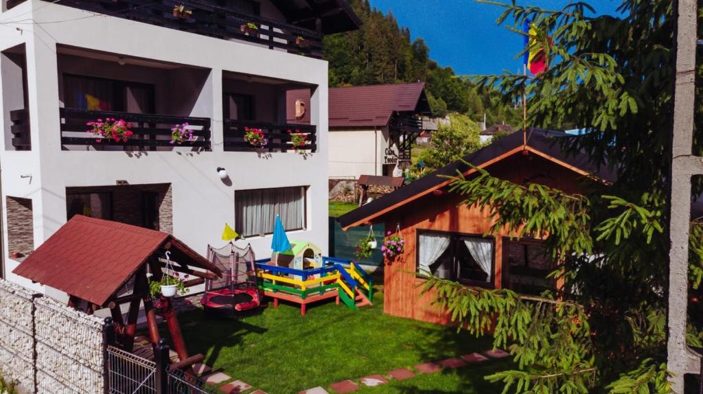 een luchtzicht op een huis met een tuin met een speeltuin bij Pensiunea “Casa De Acasa” in Rucăr