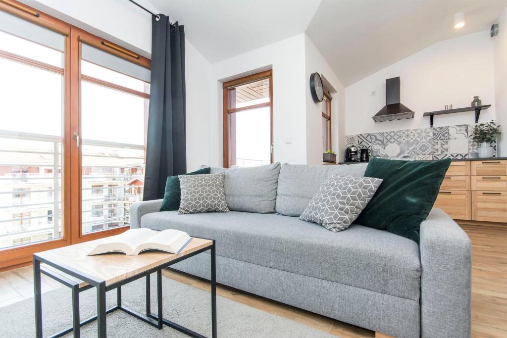 a living room with a couch and a table at Grey Rentyear Apartments in Gdańsk