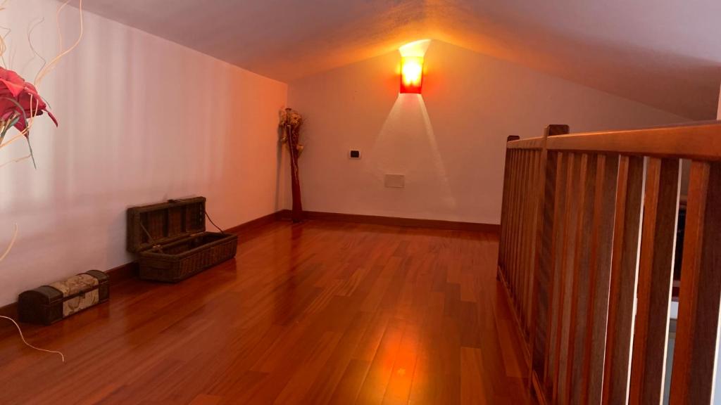 sala de estar con suelo de madera y una luz en la pared en Casa Sofia vista porto en Olbia