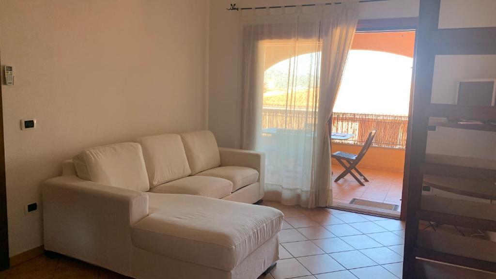 a living room with a white couch and a balcony at Casa Sofia vista porto in Olbia