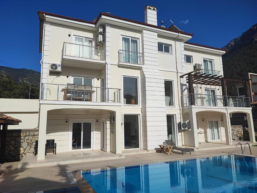 a large white building with a swimming pool in front of it at Villa Holly in Fethiye