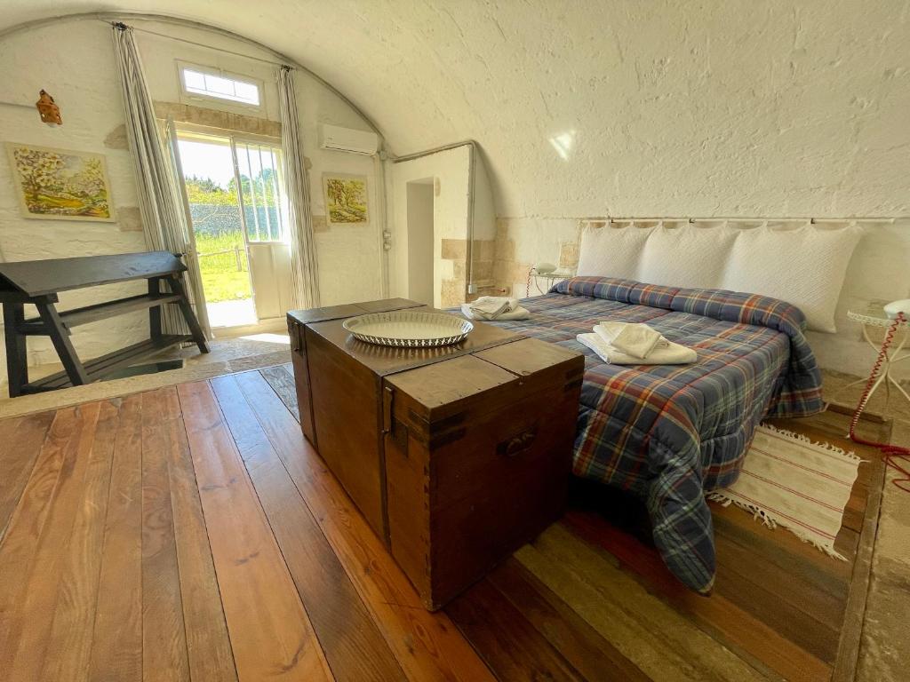 a bedroom with a bed with a table and a window at Tenuta Sant'Andrea in Muro Leccese