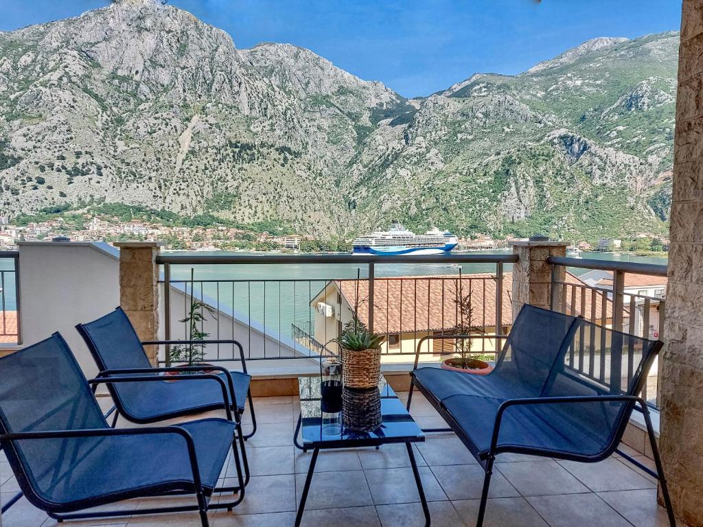 a balcony with chairs and a view of mountains at J&M apartment in Kotor