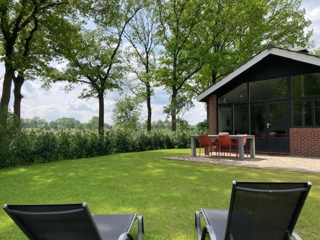 twee stoelen en een tafel in de tuin bij Achterhoekse vakantiewoning, infraroodsauna, geweldig uitzicht, goede bedden in Aalten