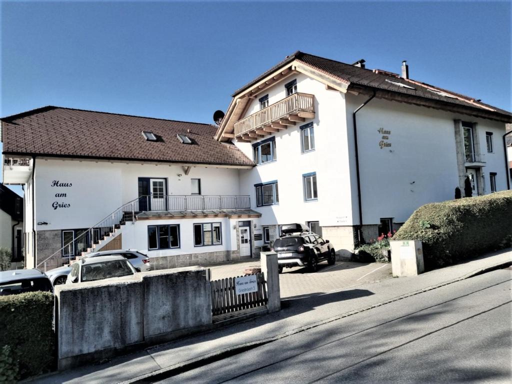 un gran edificio blanco con coches estacionados frente a él en Haus am Gries, en Murnau am Staffelsee