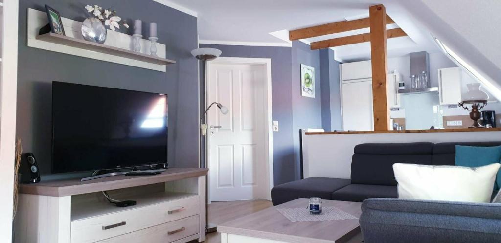 a living room with a tv and a couch at Ferienwohnung Anna in Marienhafe