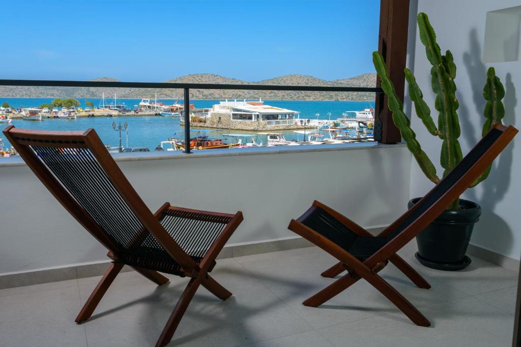 2 sillas en un balcón con vistas al puerto en apagio project by almelon houses en Eloúnda