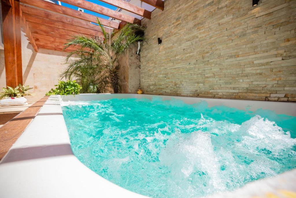 a bath tub with blue water in a room at Room in Guest room - Central Area Bedroom With Common Kitchen, living room in Sosúa