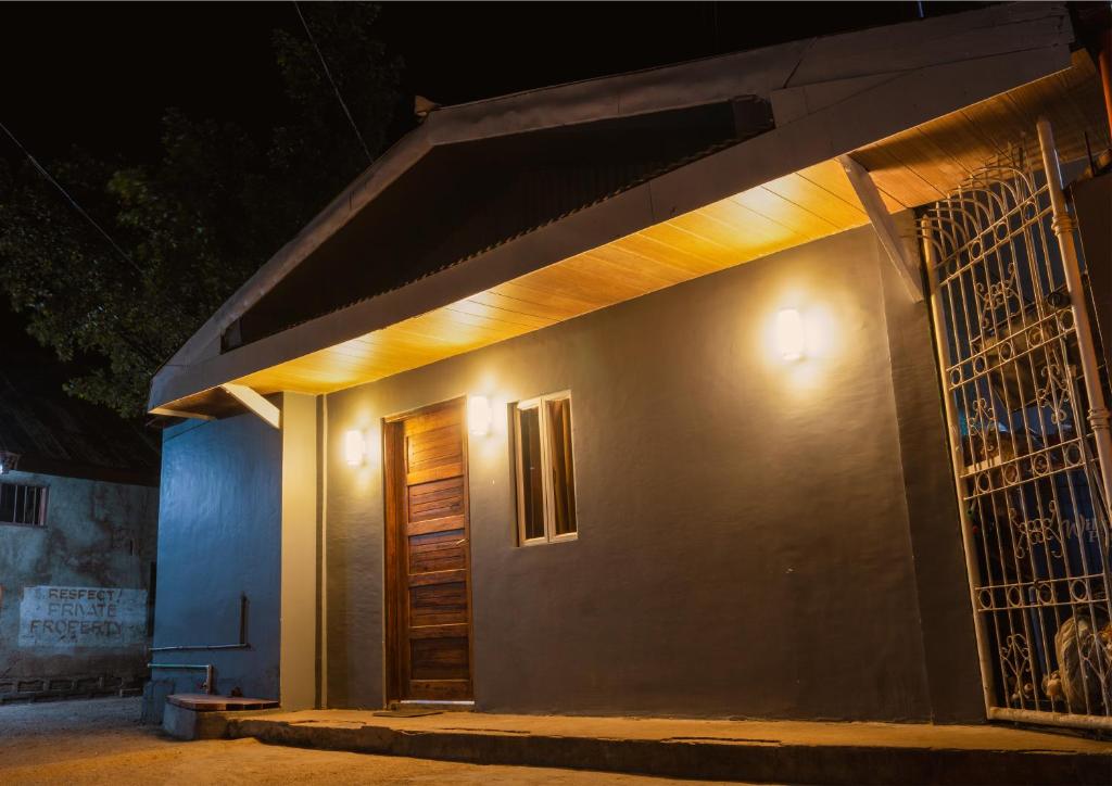 uma casa com luzes de lado à noite em B&B Backpackers em Coron