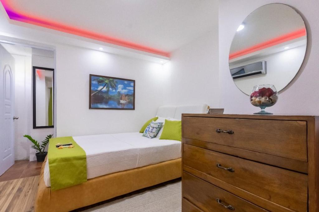 een slaapkamer met een bed, een dressoir en een spiegel bij Room in Guest room - Nice 1br-1bt With Common Picuzzi in Sosúa