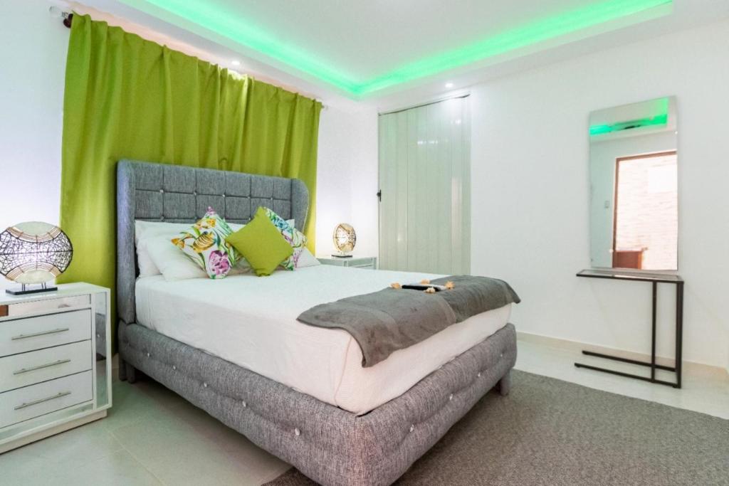 um quarto com uma cama grande e cortinas verdes em Room in Guest room - Cozy 1bd with common Jacuzzi em Sosúa