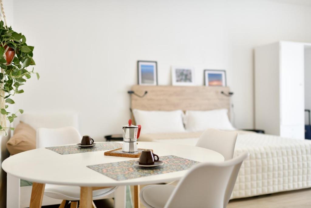een kamer met een witte tafel en stoelen en een bed bij Florida Casa Vacanze in Alghero