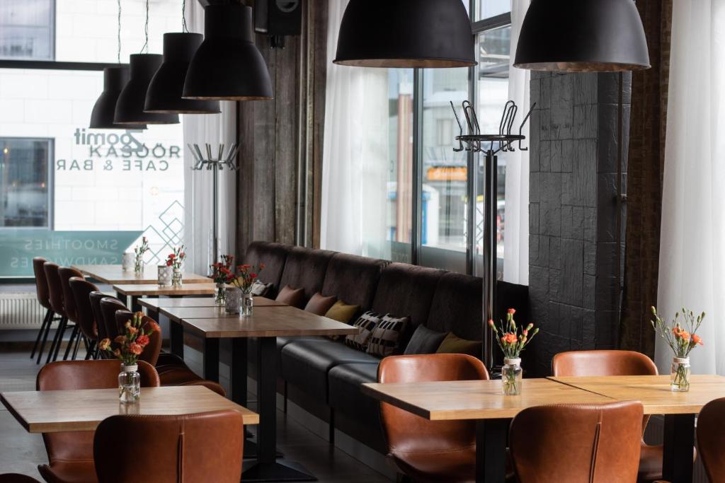 a restaurant with wooden tables and leather chairs at Santa's Hotel Santa Claus in Rovaniemi