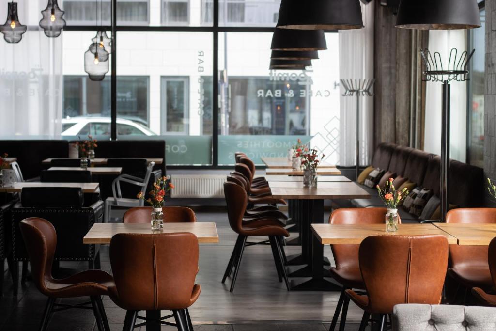 a restaurant with wooden tables and chairs and windows at Santa's Hotel Santa Claus in Rovaniemi