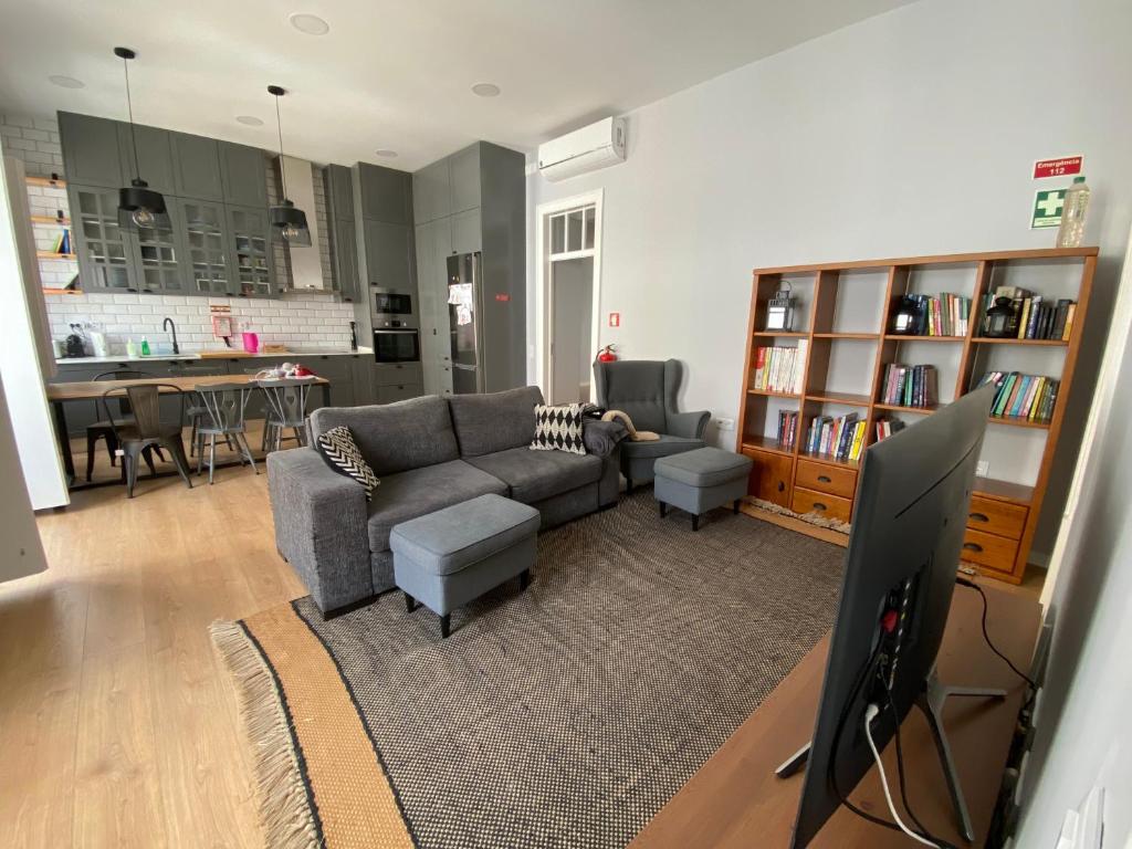 uma sala de estar com um sofá e uma televisão em Casa da Serpa Pinto em Évora