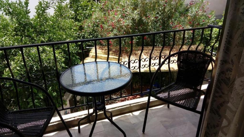 a glass table and two chairs on a balcony at Kadmos in Loutra Edipsou