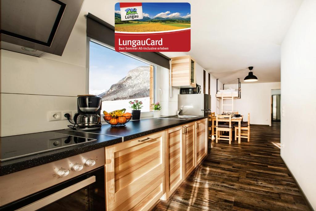 a kitchen with a counter top and a large window at Fischer Ferienhaus in Tweng