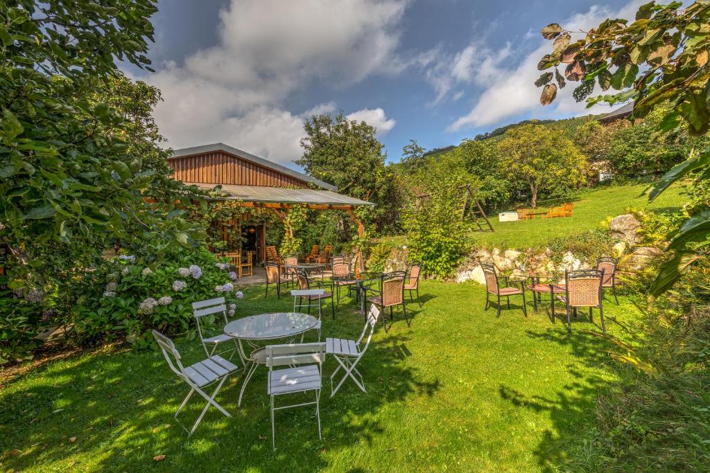 eine Terrasse mit Tischen und Stühlen im Gras in der Unterkunft Pension Auf der Olk mit Röpertsmühle in Veldenz