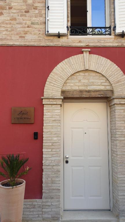 an archway with a white door in front of a building at Italian Experience-Aghel Luxury Apartment in Recanati