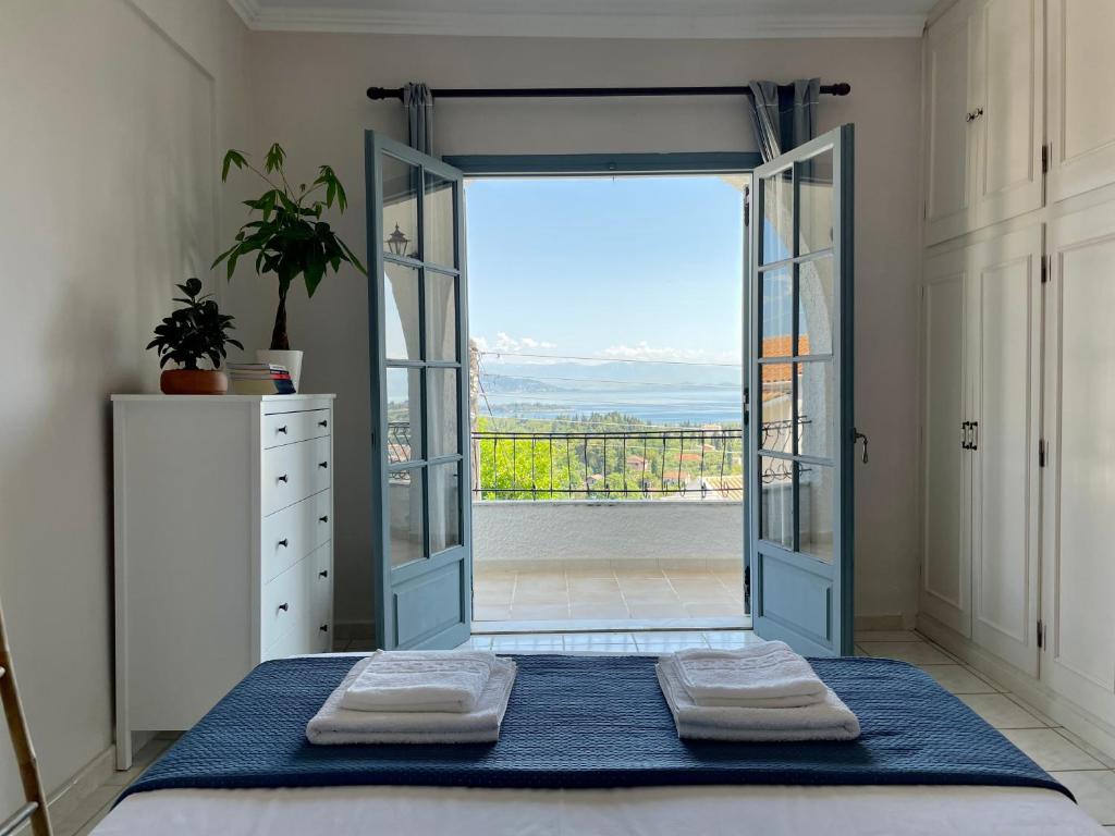 a bedroom with a door open to a balcony at Panoramic View Of Corfu Island in Giannádes