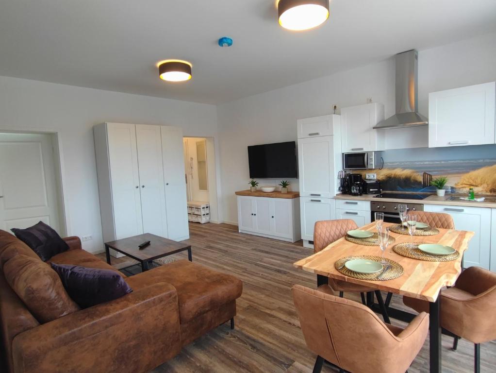 a kitchen and living room with a table and a couch at Villa Boberg Apartments in Ostseebad Koserow