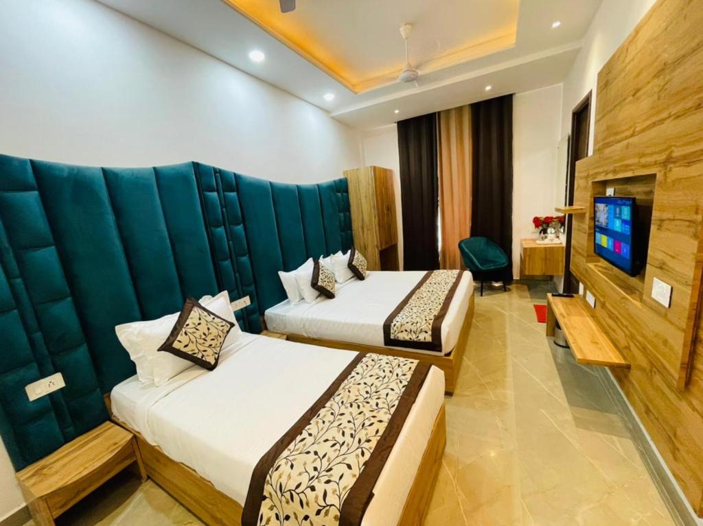 a hotel room with two beds and a television at Hotel Dream Town By Cozy Hotels & Resorts in Amritsar