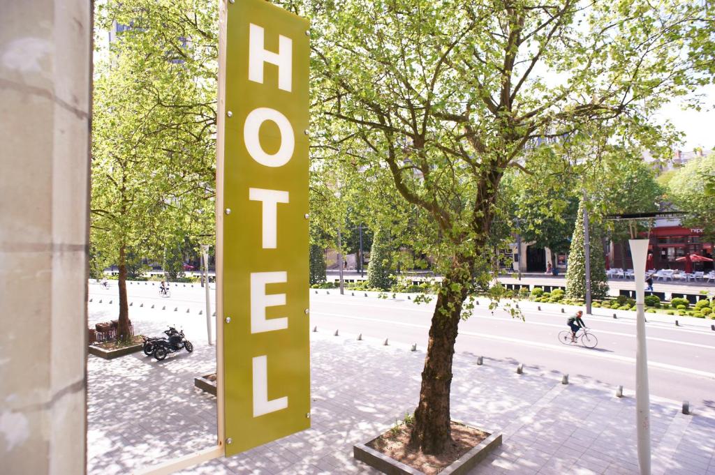 um grande sinal que diz Hollywood ao lado de uma árvore em Logis Hôtel Duquesne em Nantes