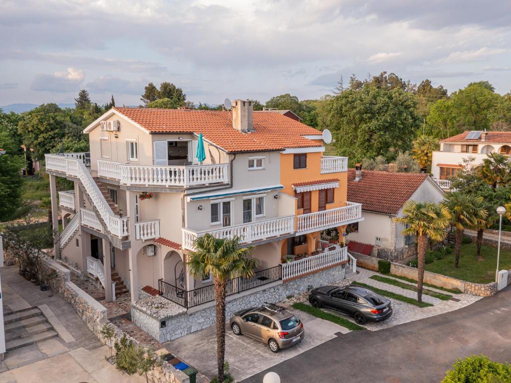 een luchtzicht op een huis met auto's aan de voorkant bij Apartments Dino in Malinska