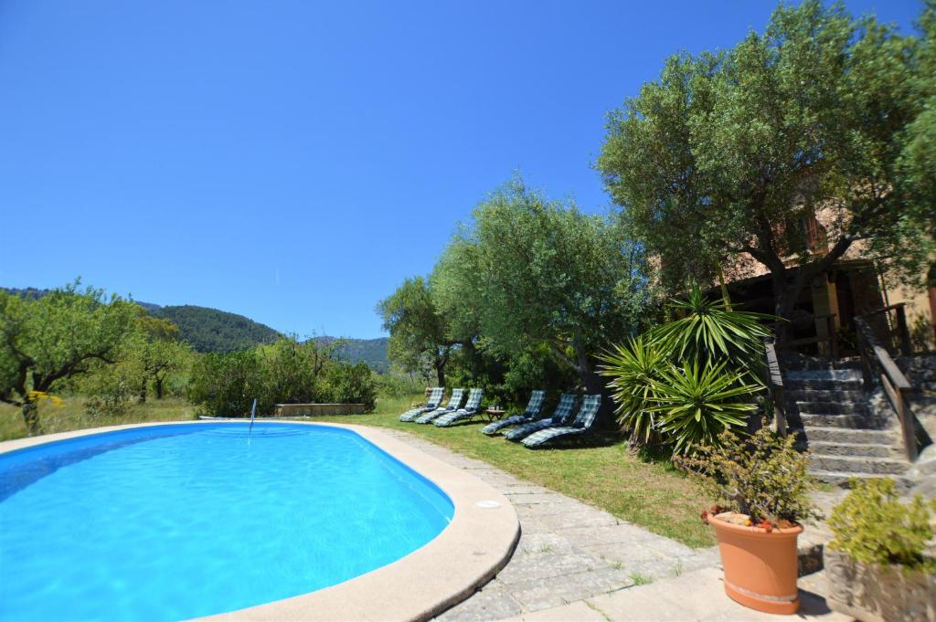- une piscine dans une cour avec des chaises et des arbres dans l'établissement Es Talaiot, à Puigpunyent