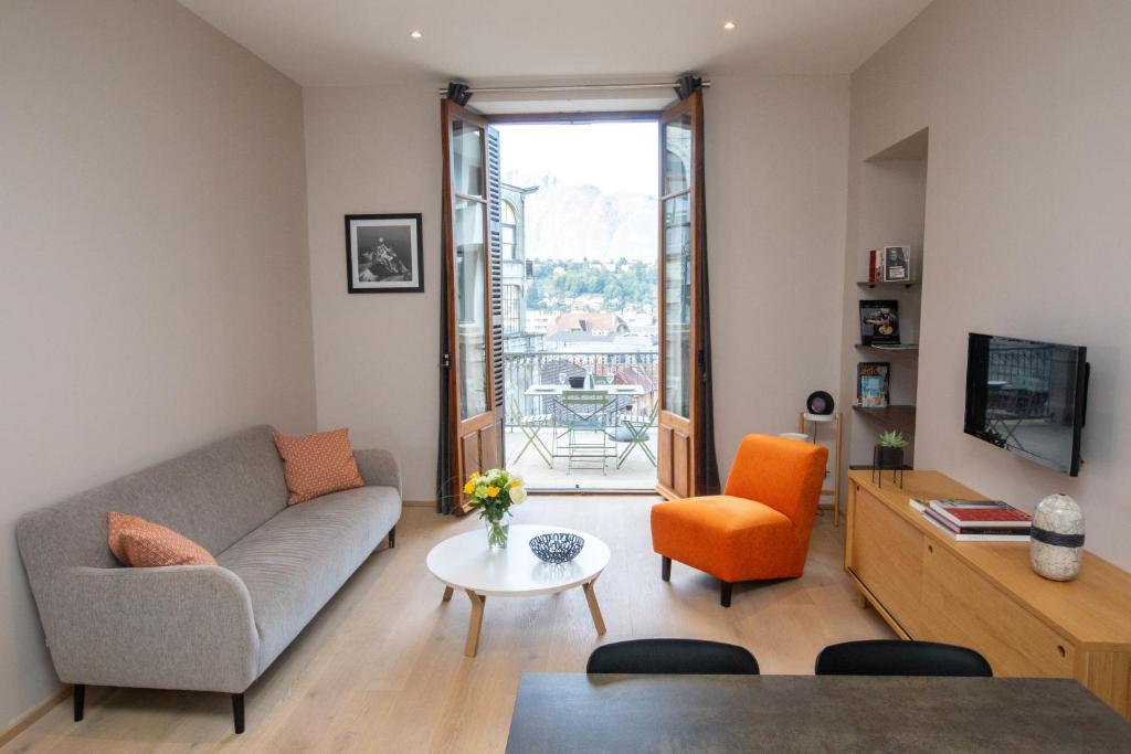 a living room with a couch and a table at Villa Saint Enogat in Aix-les-Bains