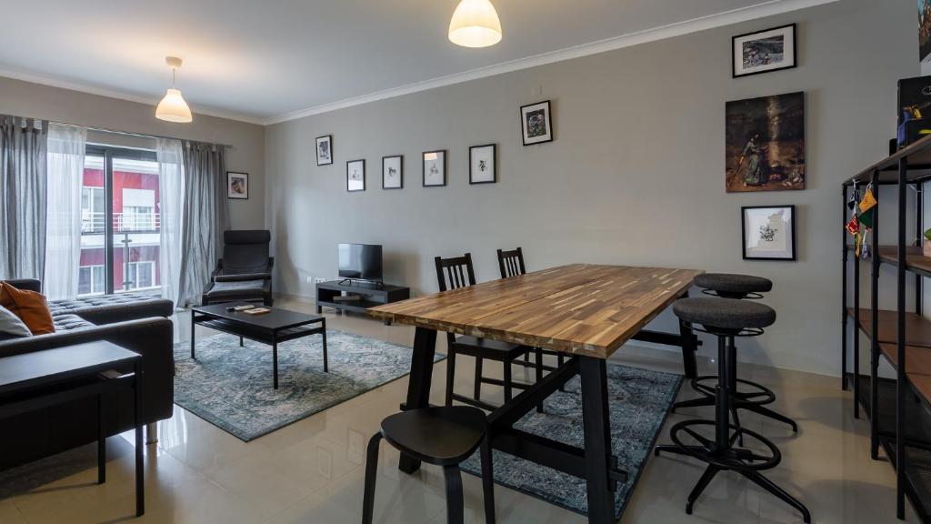 - un salon avec une table et des chaises en bois dans l'établissement Spacious & Modern 3BDR Apartment in Algarve by LovelyStay, à Silves