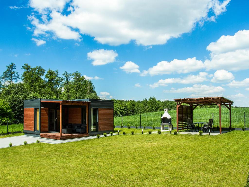 a tiny house in a field with a gazebo at Osada Blisko Natury in Gniezno