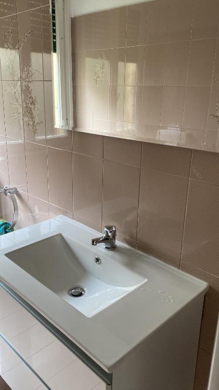 y baño con lavabo blanco y espejo. en La casa di Andrea Grande Appartamento a due passi dalle spiagge, en Rapallo