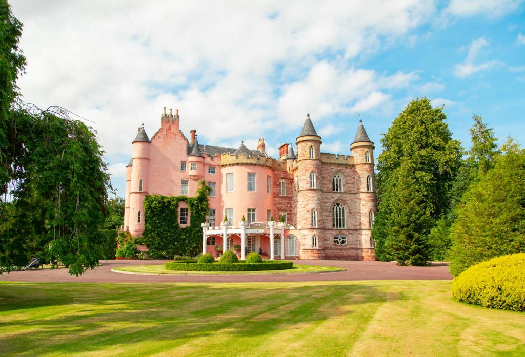 an old castle with a lawn in front of it at Balnagown Estates in Kildary