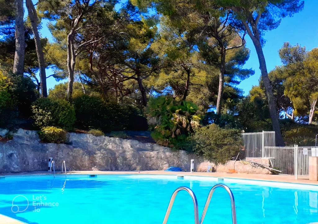 une piscine d'eau bleue et d'arbres dans l'établissement T1 avec Piscine à 300m des Plages pour 4 personnes - Résidence SAINT ELME, à La Seyne-sur-Mer