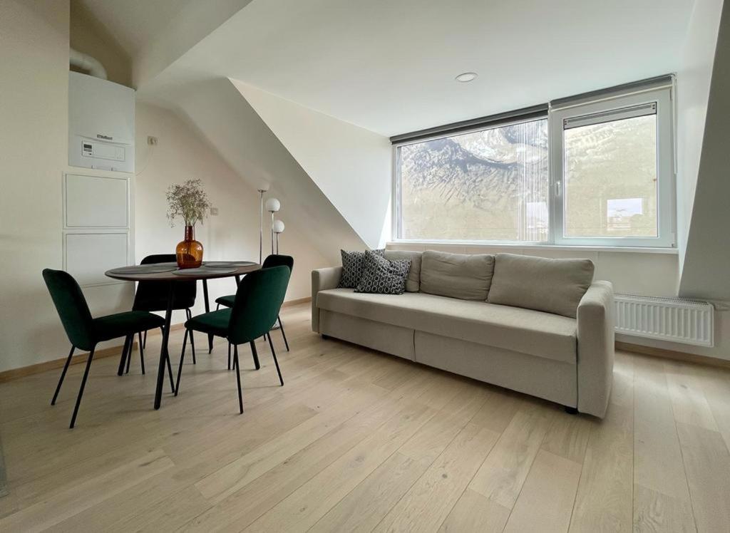 a living room with a couch and a table and chairs at Charming duplex on the canal Brussels in Brussels