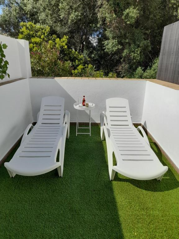 two chairs and a table on a patio with grass at La casa de la luz in San Fernando